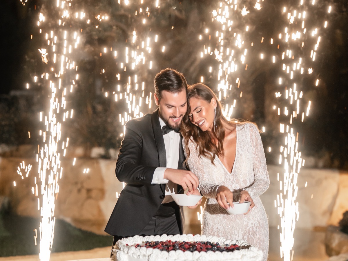 Sposi che tagliano la torta nuziale tra le fontane luminose